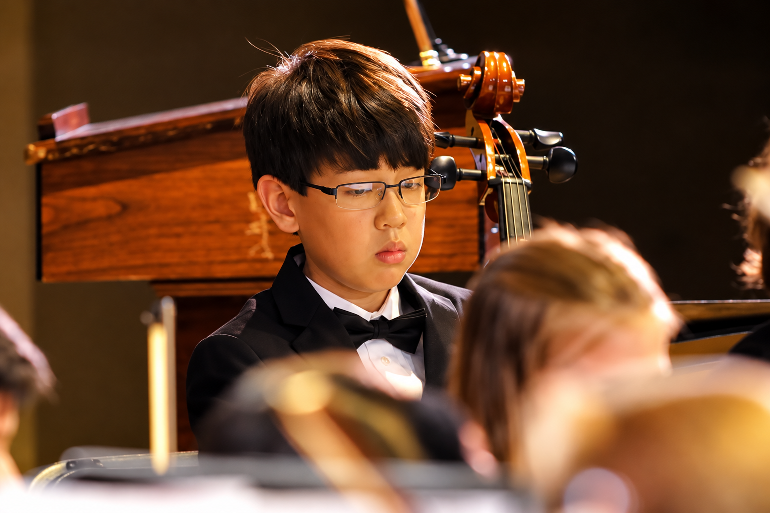 Young beginner orchestra students with small string instruments, black and white photography, classical music education